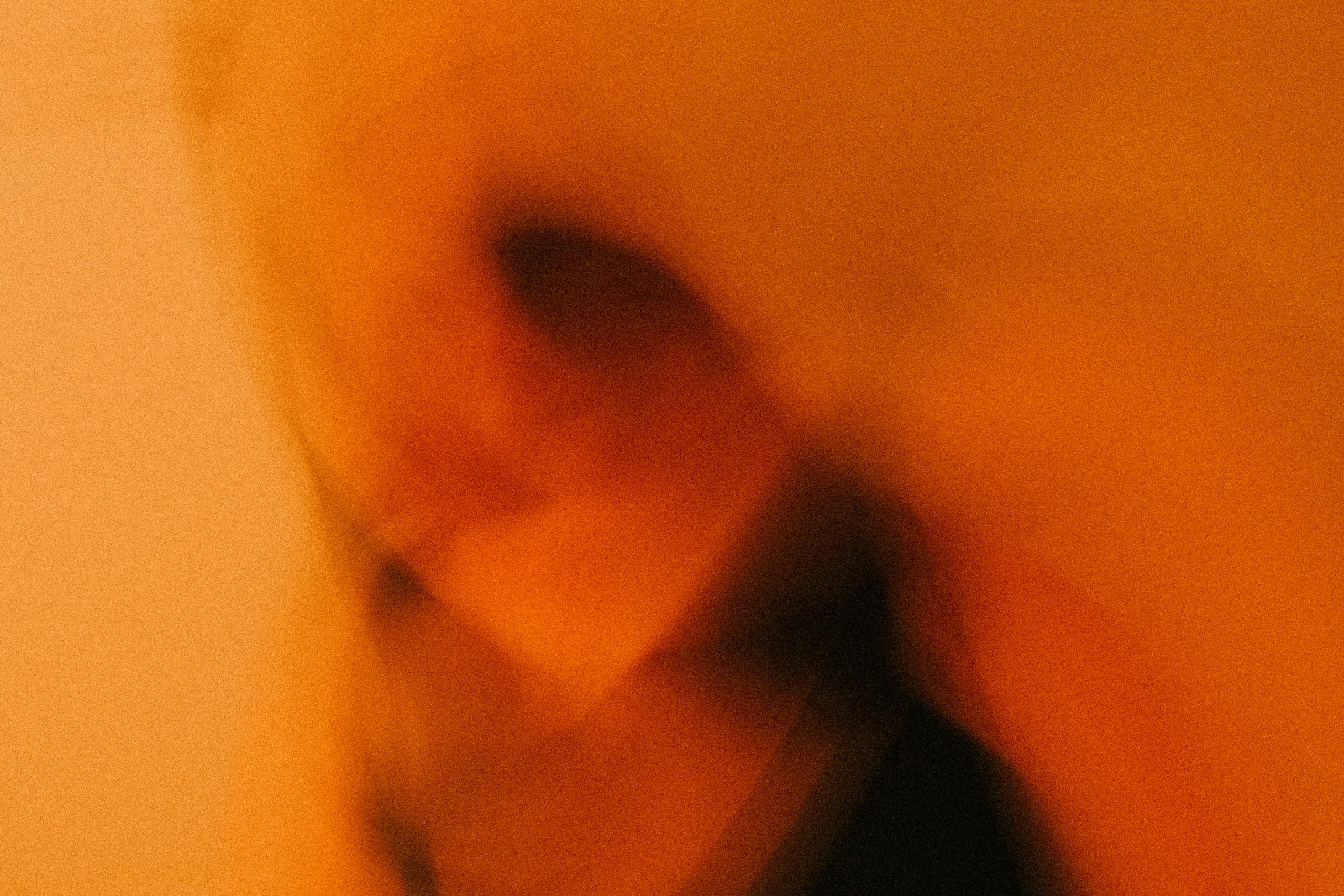 Dynamic blurred image with warm orange tones and abstract motion effects.